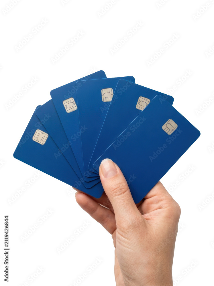 © IDA FAR - A hand holding a fan of blank blue credit cards against a clean white background in a minimalist studio shot with a professional mood.