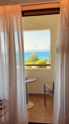 Luxury hotel room overlooking an infinity pool, crystal-clear Mediterranean Sea, lush green nature, panoramic coastal view, sunny summer day