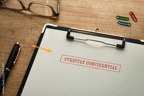 Strictly confidential mock document staged on wooden desk — ideal for data security and compliance articles