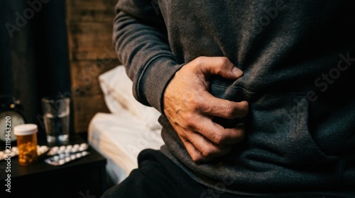 Struggling With Abdominal Discomfort Holding Stomach In Bed
