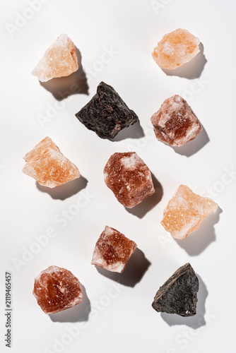 Obraz na płótnie 白背景に俯瞰で並ぶピンク岩塩と黒岩塩の天然結晶