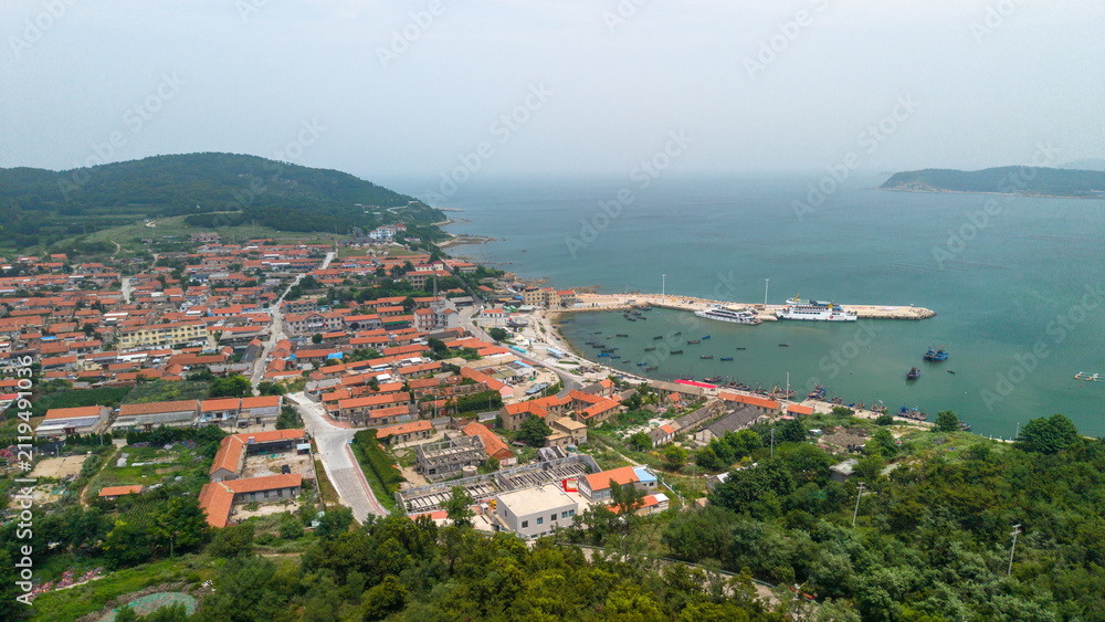 Naklejka premium Coastal Fishing Village With Harbor On Sunny Day