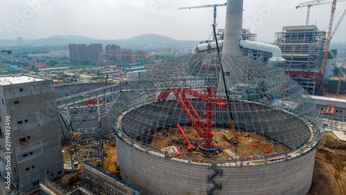 Fotografie Circular Industrial Building Under Construction With Cranes