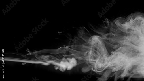 фотографія A thick cloud of white smoke expands and dissipates into the darkness, revealing complex internal structures and patterns formed by the swirling vapor
