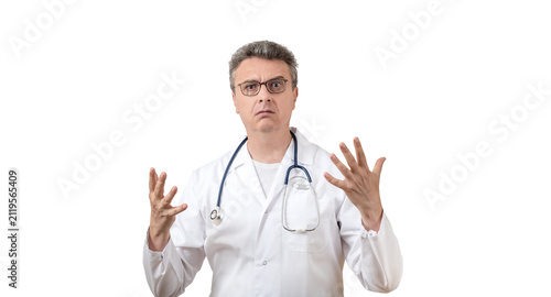 Fotografie A middle-aged male doctor in a white coat, with an angry expression and an emotional gesture, against a white background
