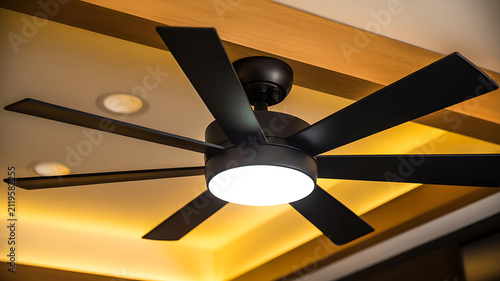Black Six Blade Ceiling Fan with Integrated Light and Warm Ambient Lighting on Ceiling