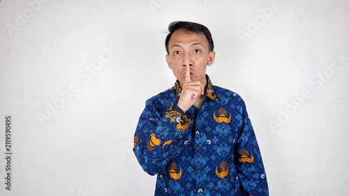 Young male civil servant making a shut up gesture in white background