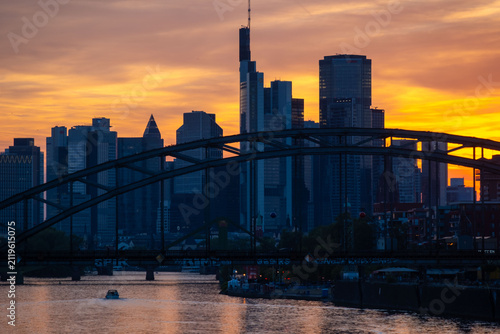 Vibrant urban sunset with river Main and arched bridge, modern Frankfurt am Main skyline, financial district, skyscraper facade, Germany travel, Europe infrastructure, Frankfurt