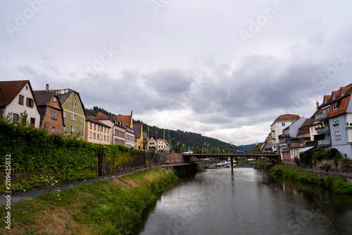 River flows through town with bridge and buildings.