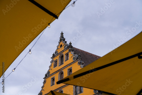 Yellow building with ornate facade under cloudy sky.