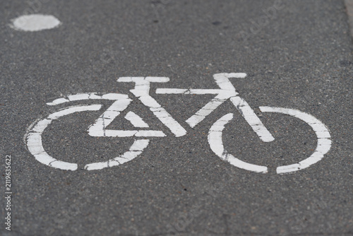 Markings on asphalt show a bicycle symbol in a bike lane during daytime