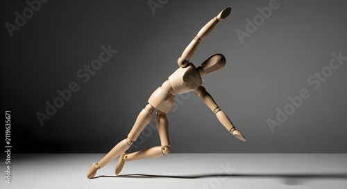 Wooden mannequin in a dynamic falling pose. Articulated human figure model for drawing.