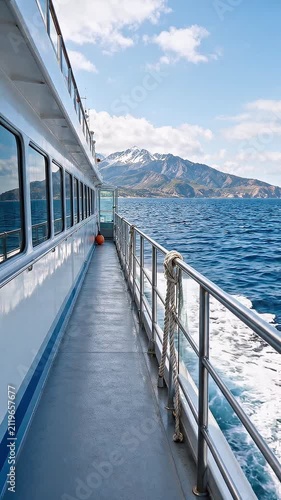 Empty cruise ship deck overlooking ocean and mountains