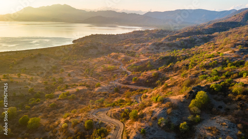 Foto Aerial View of Winding Mountain Road Through Dry Hills in Sumbawa, Indonesia