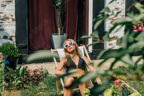woman in swimsuit lounging in garden during summer heatwave