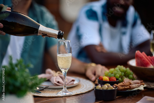 Close up of friends celebrating summer with champagne.