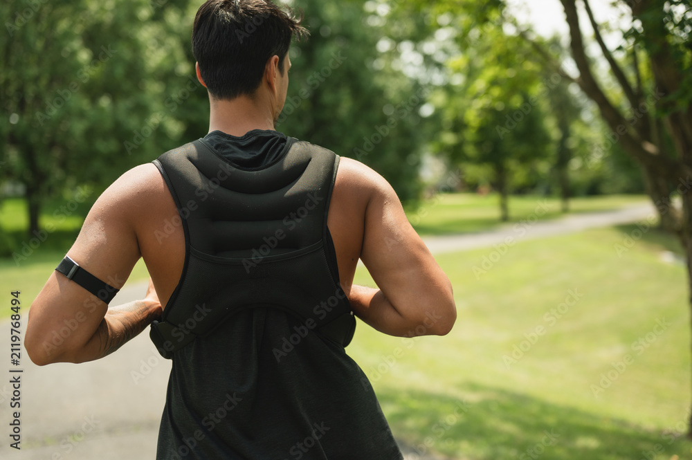 Fototapeta premium Athletic man training outdoors with a weighted vest