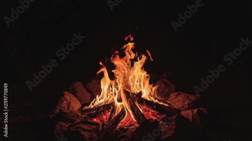 Warm campfire burning brightly with glowing embers at night