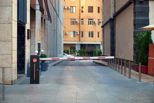 Automatic barrier at the entrance to the parking lot in inner court residential building.