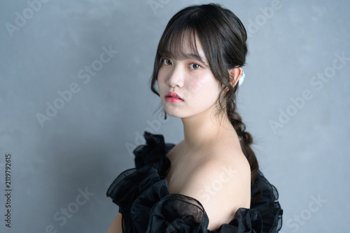 グレー背景で黒いドレスを着た日本人女性
