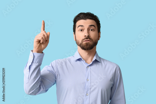 Young man pointing up on bl...