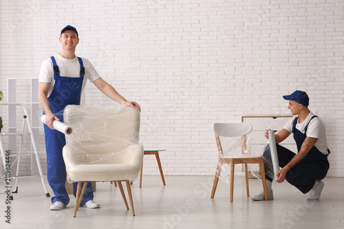 Male loaders wrapping chair...