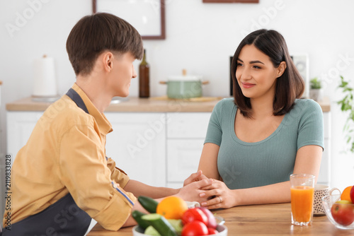 Young pregnant couple holdi...