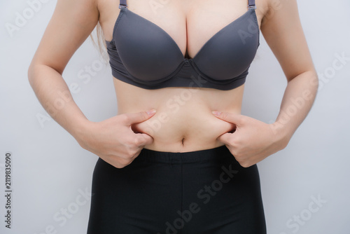 Foto Body Fat Pinch: A person pinching their abdomen, highlighting body fat and the desire for a slimmer physique