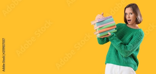 Surprised young woman holdi...
