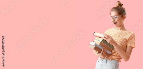 Happy young female student with a stack of books, education and learning conc...