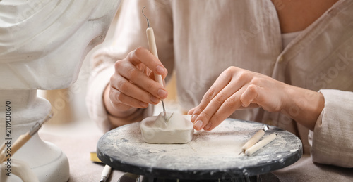 Artist's hands sculpting cl...