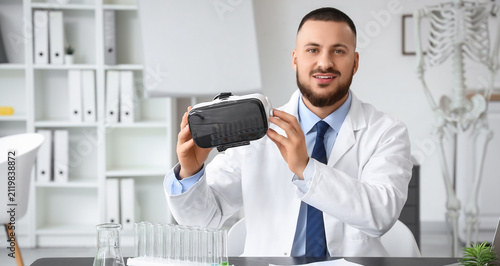 Smiling male doctor in a la...