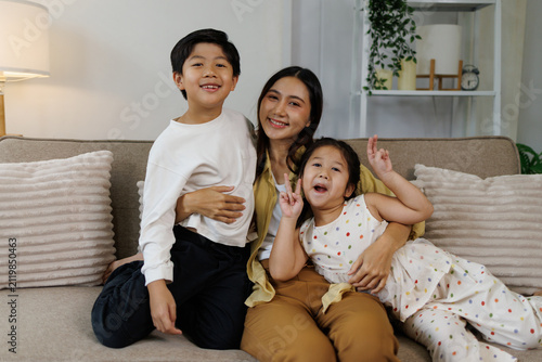 Foto Asian mother embracing son and daughter, family bonding at home, enjoying happy
