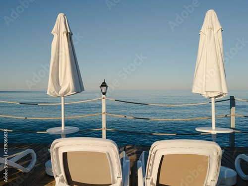 Canvastavla Sun loungers and umbrellas on a wooden beach pier