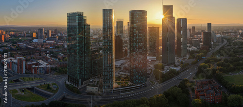 Fotografie Golden Sun Flare Behind Deansgate Square Skyscrapers in Manchester at Dawn