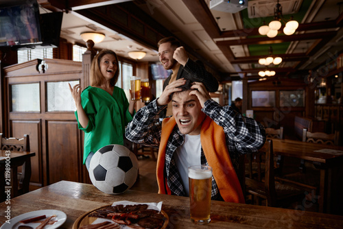 Принти на полотні Celebrating supporters share spontaneous hugs and cheers amid festive party atmo