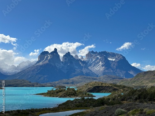 Iconic Cuernos del Paine rising above vivid turquoise glacial waters beneath a deep blue sky in Torres del Paine National Park, Chile.