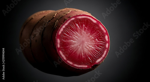 Fresh cut cross section of a red root vegetable with vegetable, ingredient