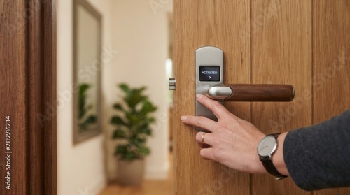 Person hand pressing button door handle Man using a biometric fingerprint scanner to unlock modern