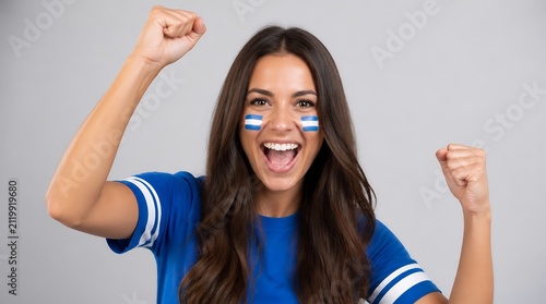 Excited Female Soccer Fan Cheering with Argentina Flag Face Paint and Blue Jersey.