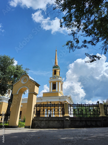 Exterior facade of Transfiguration Cathedral in classicism style with white columns and golden dome under blue sky in Dnipro, Ukraine.