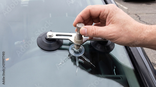 Resin injector bridge repairing a star-shaped windshield chip