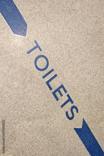 Directional Signage to Restrooms on Concrete Surface for Public Spaces Guidance