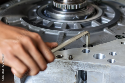 фотографія Close up of a mechanic using an allen key to assemble an industrial engine component