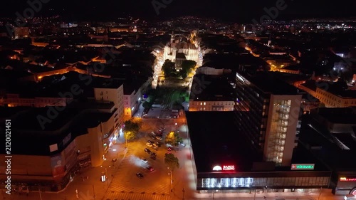 Night aerial footage of the historic center of Kosice, Slovakia, showing St. Elisabeth Cathedral, the Urban Tower and the city’s main square. The drone view highlights the illuminated Gothic landmark 