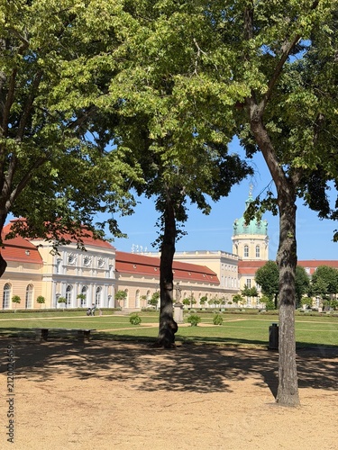 Bild auf Leinwand View of the Charlottenburg Palace and dome framed by green trees in the gardens