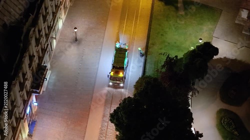 Top-down aerial footage of municipal garbage collectors working on the main square in Kosice, Slovakia. The night scene shows a waste collection truck and sanitation workers cleaning.