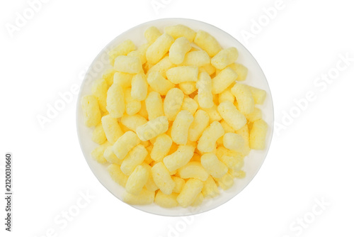Glazed corn sticks on a plate isolated on a white background. Puffed sweet snack. Top view. Sugar coated corn sticks. Gluten free.