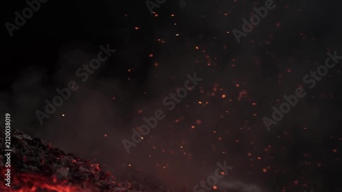 Glowing hot embers and burning fire sparks rising with smoke in the dark night