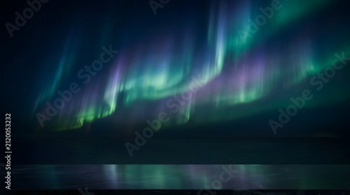 Vibrant northern lights aurora borealis display over dark landscape. Colorful night sky with green and purple celestial light streaks.